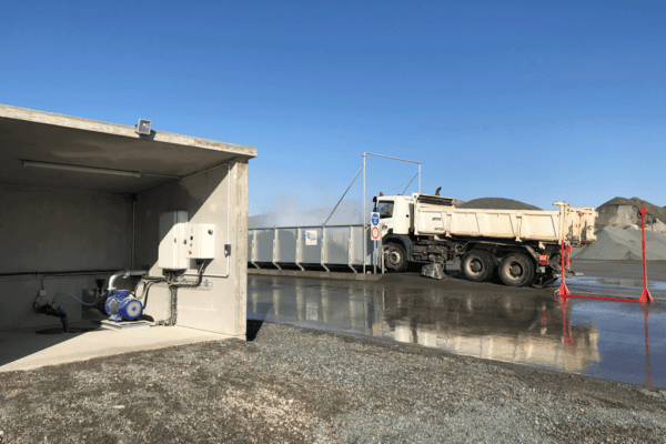 Truck passing through a wheel washer world washer