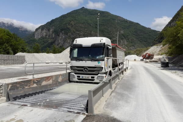 camion utilisant un laveur de roues sur un chantier